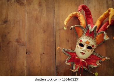 Gold And Red Elegant Traditional Venetian Jester Mask Over Old Wooden Background