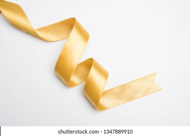 Gold Ribbon In Roll On White Background