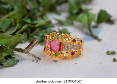 Gold Ring With Pink Stone On Green And White Background