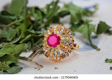 Gold Ring With Pink Stone On Green And White Background