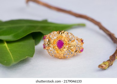 Gold Ring With Pink Stone On Green And White Background