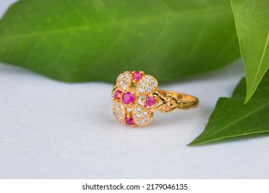 Gold Ring With Pink Stone On Green And White Background