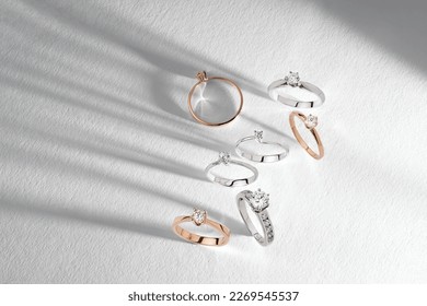 Gold rings and diamonds white background  Still life   creative photo and shadows  Diamond stacked rings group minimal concept 