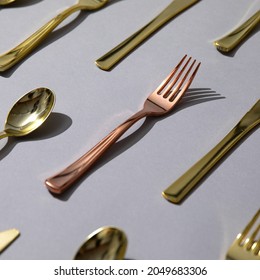 Gold And Rose Gold Fancy Eating Utensils, Dinnerware Patterns On Gray Background.  Fork, Knife, Spoon.