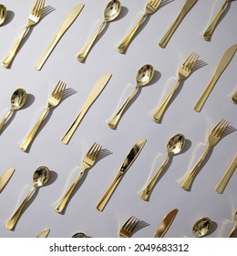 Gold And Rose Gold Fancy Eating Utensils, Dinnerware Patterns On Gray Background.  Fork, Knife, Spoon.