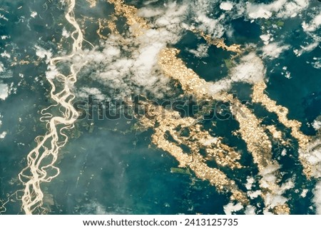 Gold Rush in the Peruvian Amazon. Gold mining pits line the rivers and cut into the rainforest. Elements of this image furnished by NASA.