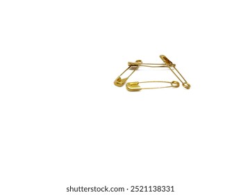 Gold safety pins are fashion accessories made of gold metal and used to embellish clothing or other accessories. Isolated on a white background