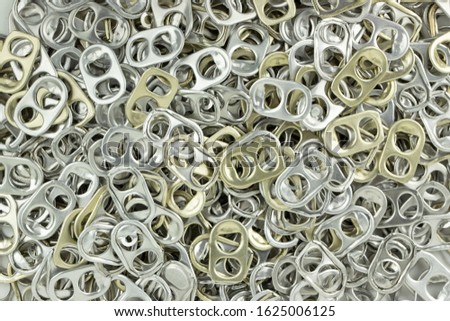 gold and silver aluminium ring pull opener or ring tabs. concept : recycle ringpulls for disable prostheses.