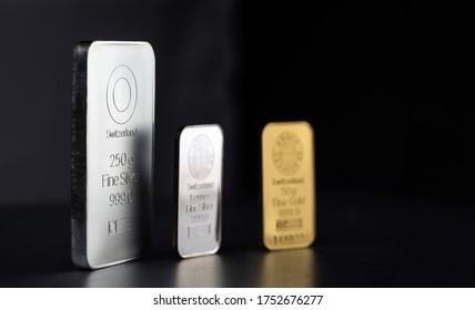 Gold and silver bars of different weights on a dark background. Selective focus. - Shutterstock ID 1752676277