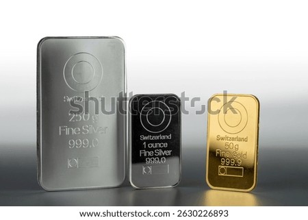 Gold and silver bars of various weights on a gray background. 