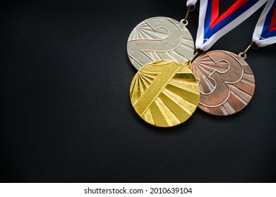 Goldmedaille und Bronze, Medaillenset, Medaillenkonzert, Foto, schwarzer Hintergrund, dunkler Bearbeitungsraum
