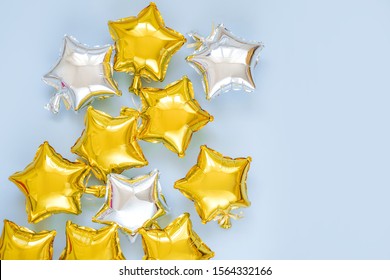 Gold and silver foil balloons of star shaped on blue background. Holiday and celebration concept. Birthday Day or party decoration. Metallic air balloons. Congratulation. Greeting card. 