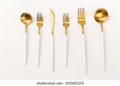 Gold Spoon Cutlery Set On White Ground