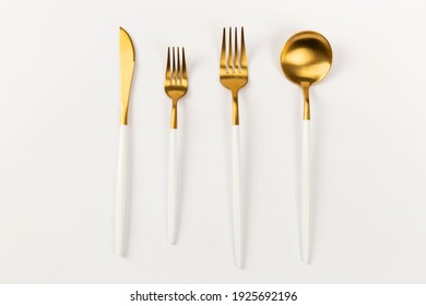 Gold Spoon Cutlery Set On White Ground