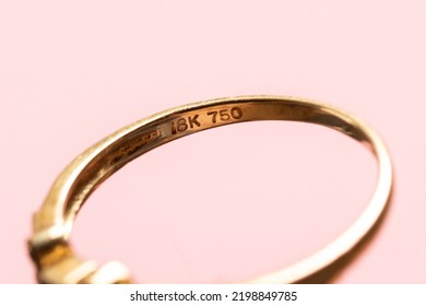 Gold stamp 18k and 750 mark icon on real golden ring, indicating the purity of gold in the jewellery. Macro detail shot - Shutterstock ID 2198849785