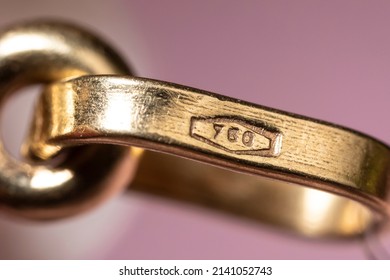 Gold stamp 750 also known as 18k mark icon on real golden pendant, indicating the purity of gold in the jewellery. Macro detail shot - Shutterstock ID 2141052743