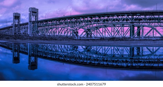 Gold Star Memorial Bridge in New London, Connecticut, the arching landmark suspending bridge over the Thames River, reflected symmetrical shapes over the water at twilight - Powered by Shutterstock