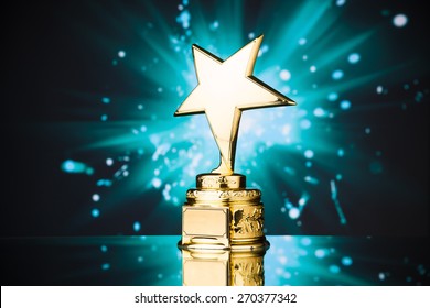 Gold Star Trophy Against Blue Sparks Background