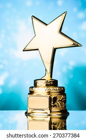 Gold Star Trophy Against Blue Sparks Background