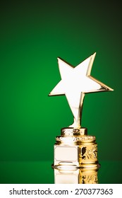 Gold Star Trophy Against Green Background