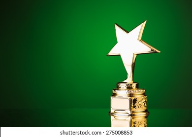 Gold Star Trophy Against Green Background