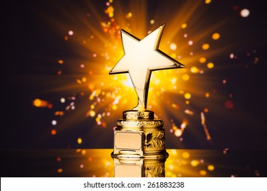 Gold Star Trophy Against Shiny Sparks Background