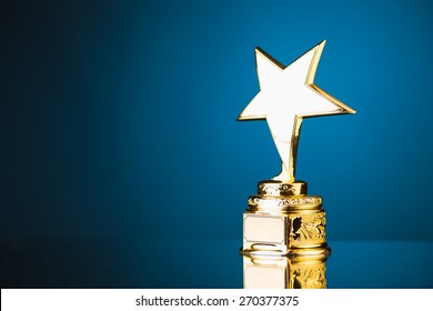 gold star trophy award against blue background