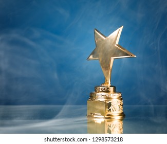 Gold Star Trophy In Smoke, Blue Background