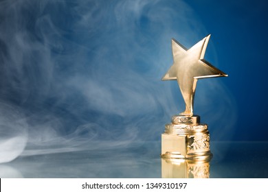 Gold Star Trophy In Smoke, Blue Background