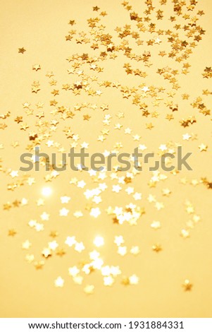 Gold stars background. Yellow glitter backdrop. Golden Christmas texture. New year luxury snow. Copyspace. Shimmer confetti wallpaper. Dreamy shiny design detail
