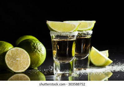 Gold Tequila Shot With Lime Fruits On Black Background