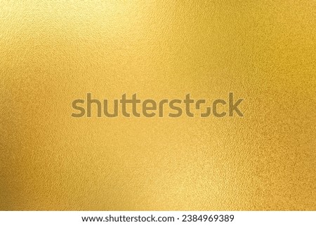 Gold wall texture background. Yellow shiny gold foil paint on wall sheet with gloss light reflection, vibrant golden paper luxury wallpaper 