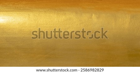 Gold wall texture background. Yellow shiny gold foil paint on wall sheet with gloss light reflection, vibrant golden paper luxury wallpaper 
