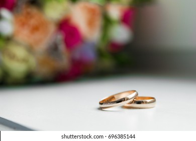Gold wedding rings on the wedding bouquet of the bride