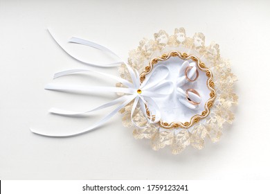 Gold Wedding Rings On A Lace Wedding Pillow Decorated With Swans. Close-up On A White Background