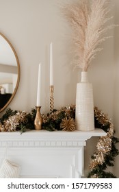 Gold And White Christmas Decor On White Mantle.