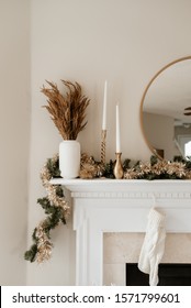 Gold And White Christmas Decor On White Mantle.