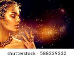 Gold Woman makeup, golden skin. Beauty fashion model girl with Golden make up, hair and jewelry on black background. Gold earrings, ring and necklace. Metallic, glance Fashion art portrait, Hairstyle.