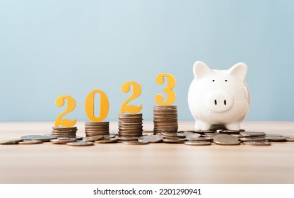 Gold wooden number year 2023 on top stack of coins with sky blue background and copy space. saving money and financial plan concept for investment in new year 2023. - Shutterstock ID 2201290941