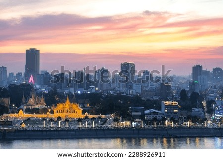 The golden afterglow over Cambodia's capital city,it's busy Riverside and famous landmarks and the Royal Palace,as the setting sun sinks from behind the Tonle Sap river.