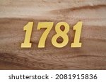 Golden Arabic numerals 1781 on a dark brown to white wood grain background.