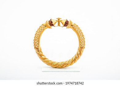 Golden bangle with beautiful work close view ideal for wedding isolated on white background. Gold jewellery stock photo.