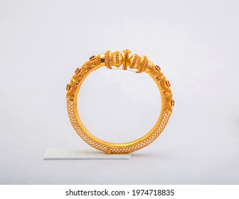 Golden bangle with beautiful work close view ideal for wedding isolated on white background. Gold jewellery stock photo.