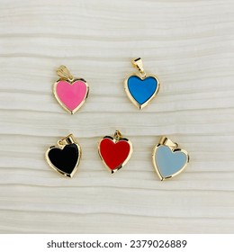 Golden basket necklaces on white background shot close up, heart locket for photos, keychains, colored heart charms