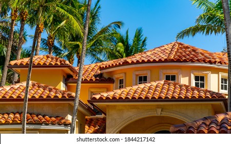 GOLDEN BEACH, FL, USA - OCTOBER 28, 2020: Barrel tile roof top luxury Florida home with colorful palms and blue sky