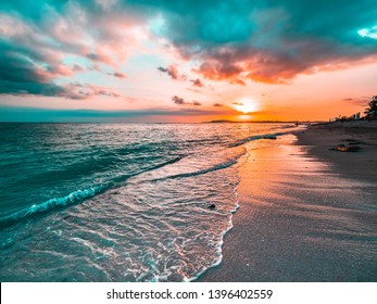 Golden beach sunset on a tropical island. Orange, teal, pink tones