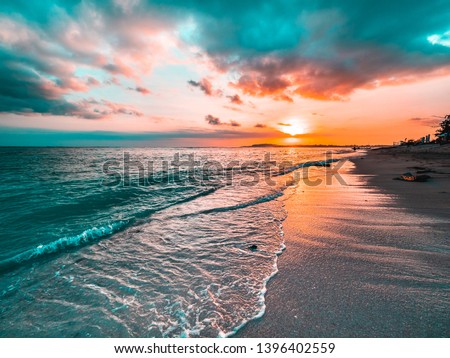 Golden beach sunset on a tropical island. Orange, teal, pink tones