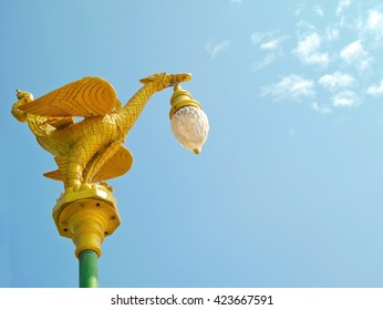 Golden bird sculpture street lamp on blue sky