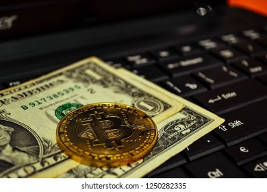 Golden bitcoin coin on a black keyboard