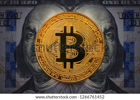 Golden bitcoin with evil, wicked Benjamin Franklin portrait from one hundred american dollars. Business concept of worldwide cryptocurrency. Earnings on cryptocurrency mining.